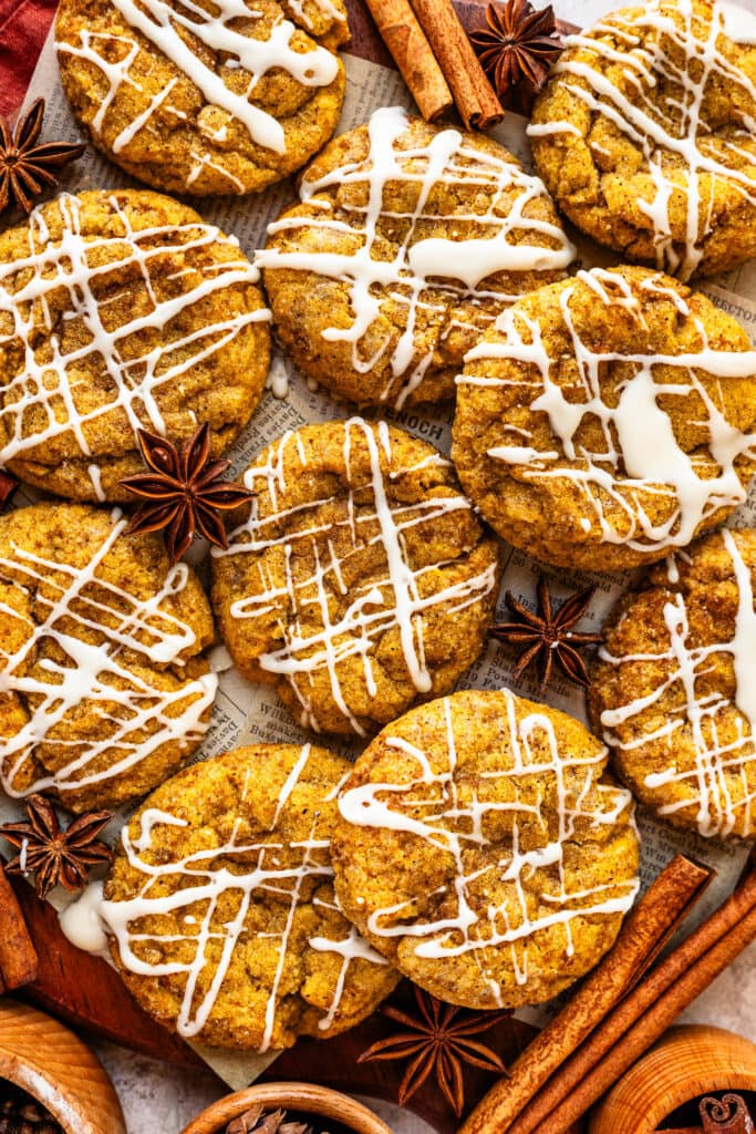 Pumpkin Cookies with glaze on top, cinnamon sticks around.