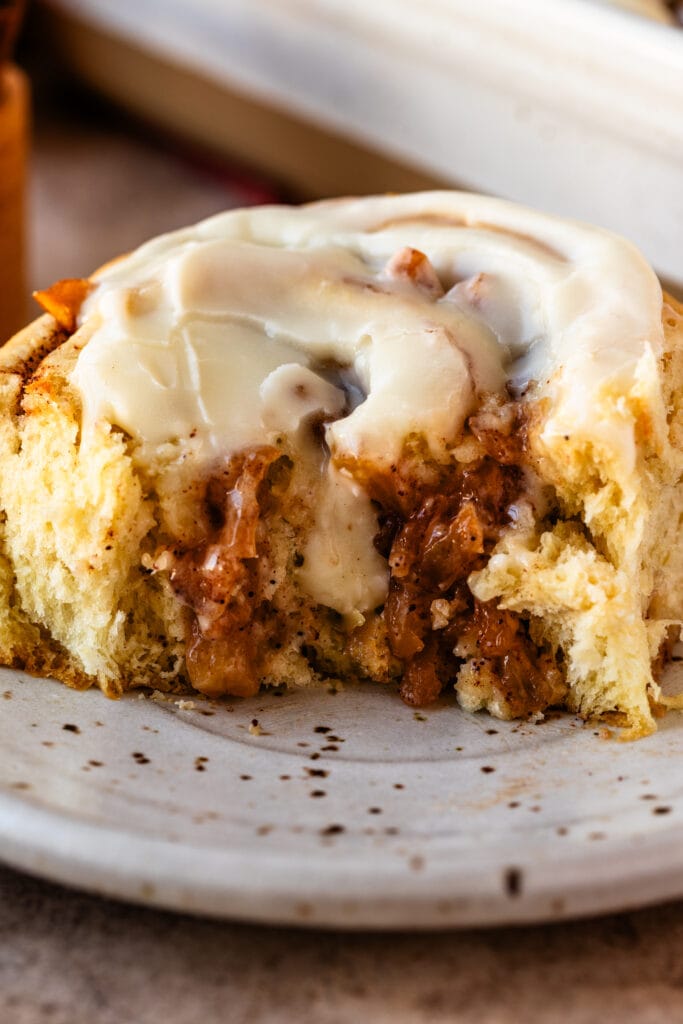 Apple Pie Cinnamon Roll on a plate, cut in half.