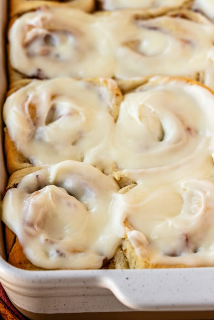 apple pie cinnamon rolls in a 9x13" tray, with glaze on top.