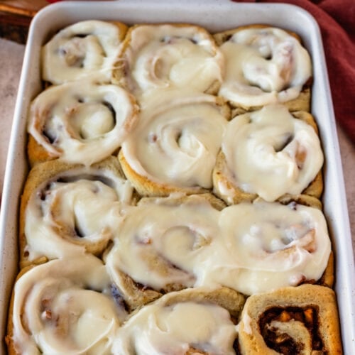 apple pie cinnamon rolls in a 9x13" tray, with glaze on top.