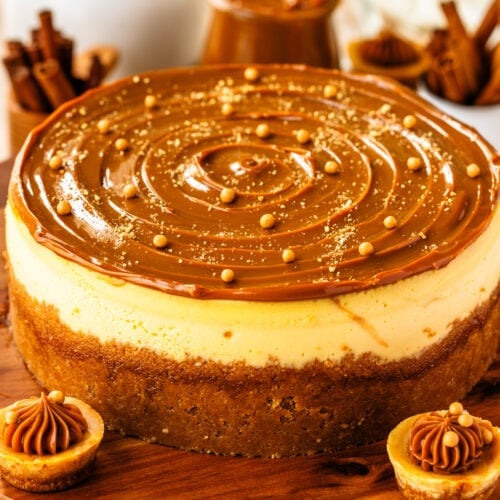 cheesecake with dulce de leche on top, and crispearls, on a wooden board.