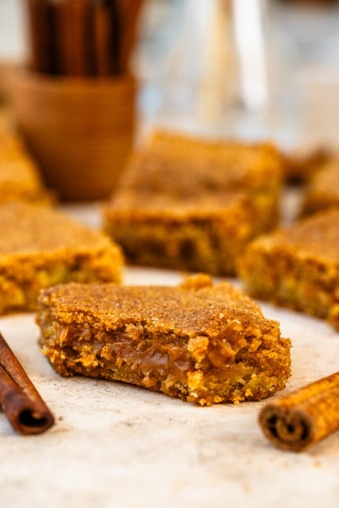 snickerdoodle bars filled with dulce de leche stacked on top of each other.