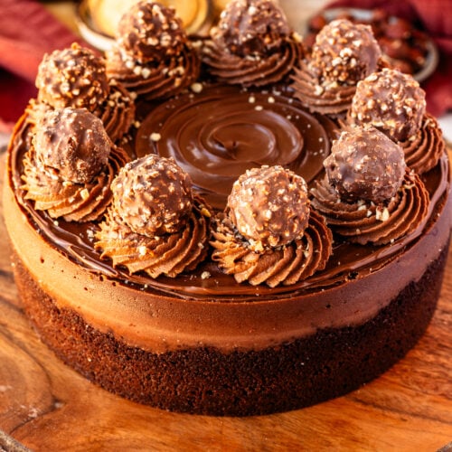 Nutella cheesecake with ferrero rocher on top and chocolate whipped cream.