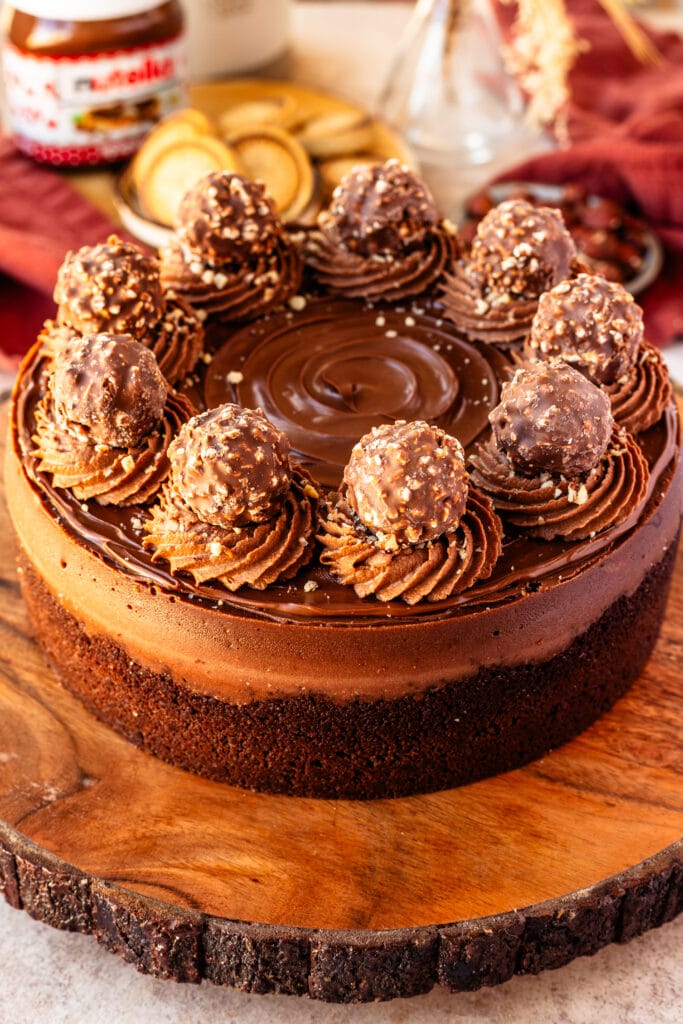 Nutella cheesecake with ferrero rocher on top and chocolate whipped cream.