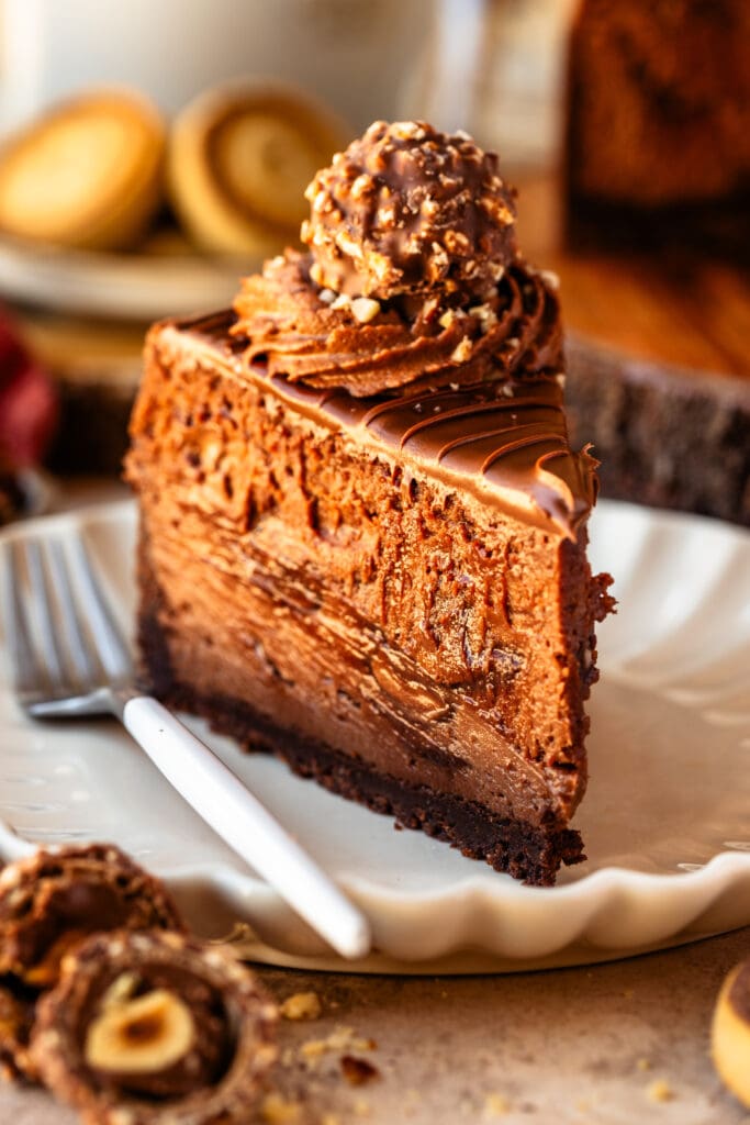 Nutella cheesecake slice with swirls of nutella, a ferrero rocher on top.
