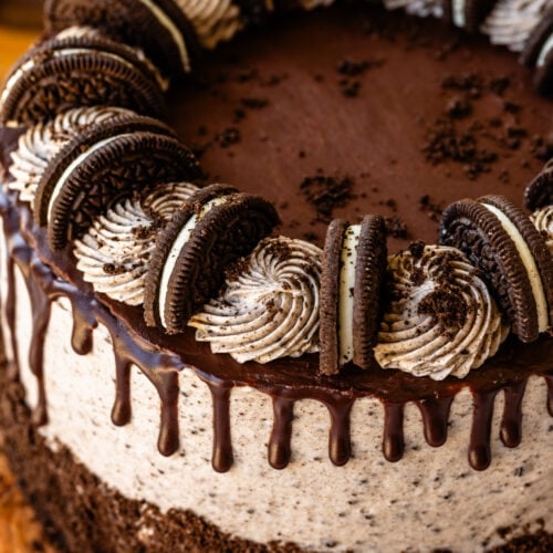 cookies and cream cake with ganache drip on top, and oreo cookies.