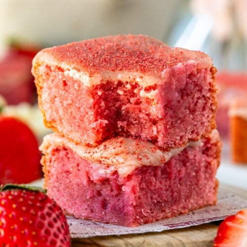 Strawberry brownies, stacked on top of each other, with strawberry ganache on top and freeze dried strawberrie powder.