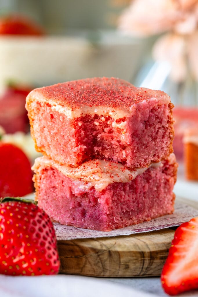 Strawberry brownies, stacked on top of each other, with strawberry ganache on top and freeze dried strawberrie powder.