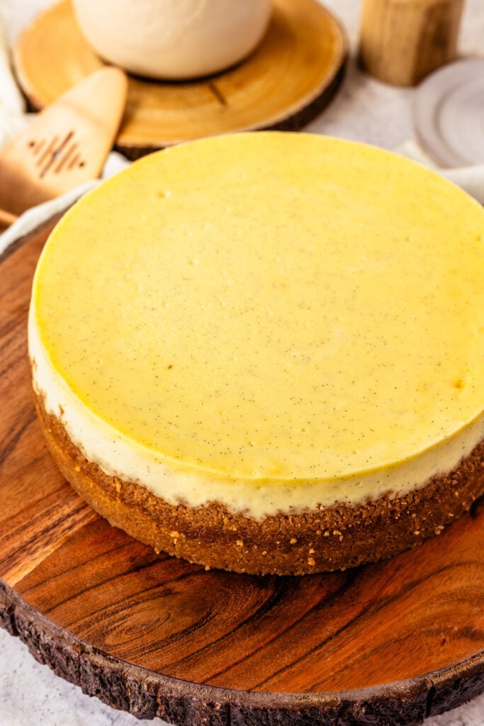 Crème Brûlée Cheesecake on top of a wooden board.