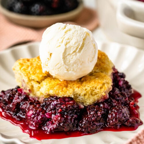 Blackberry cobbler in a plate topped with ice cream.