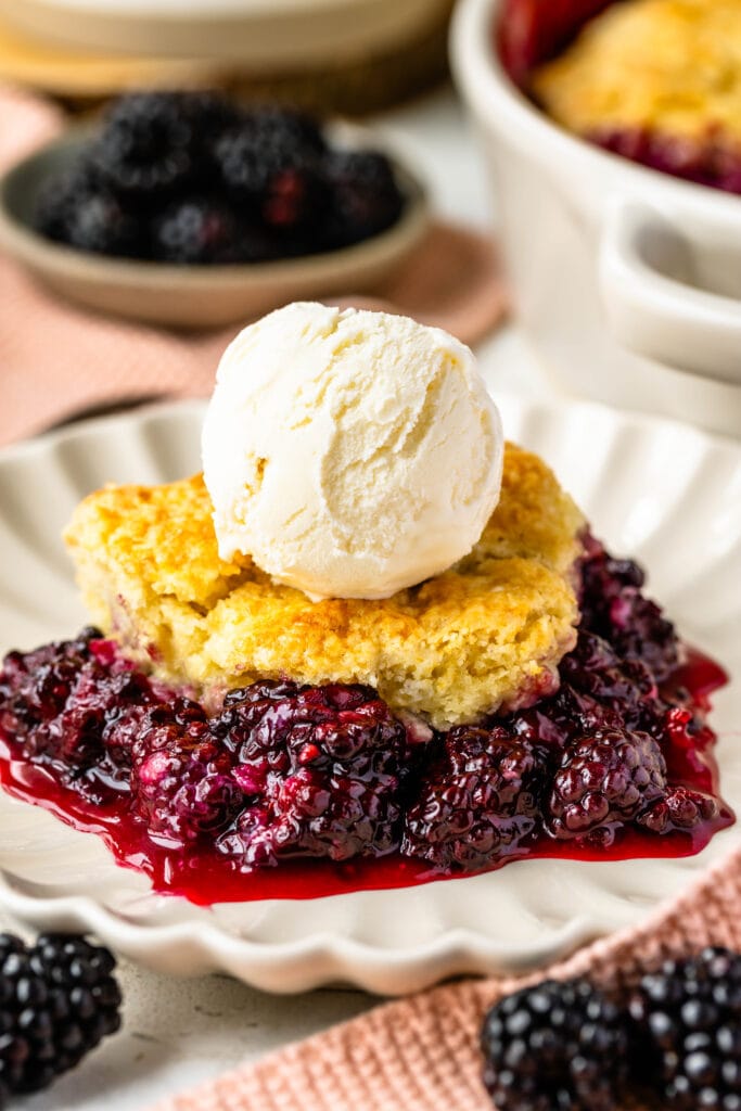 Blackberry cobbler in a plate topped with ice cream.