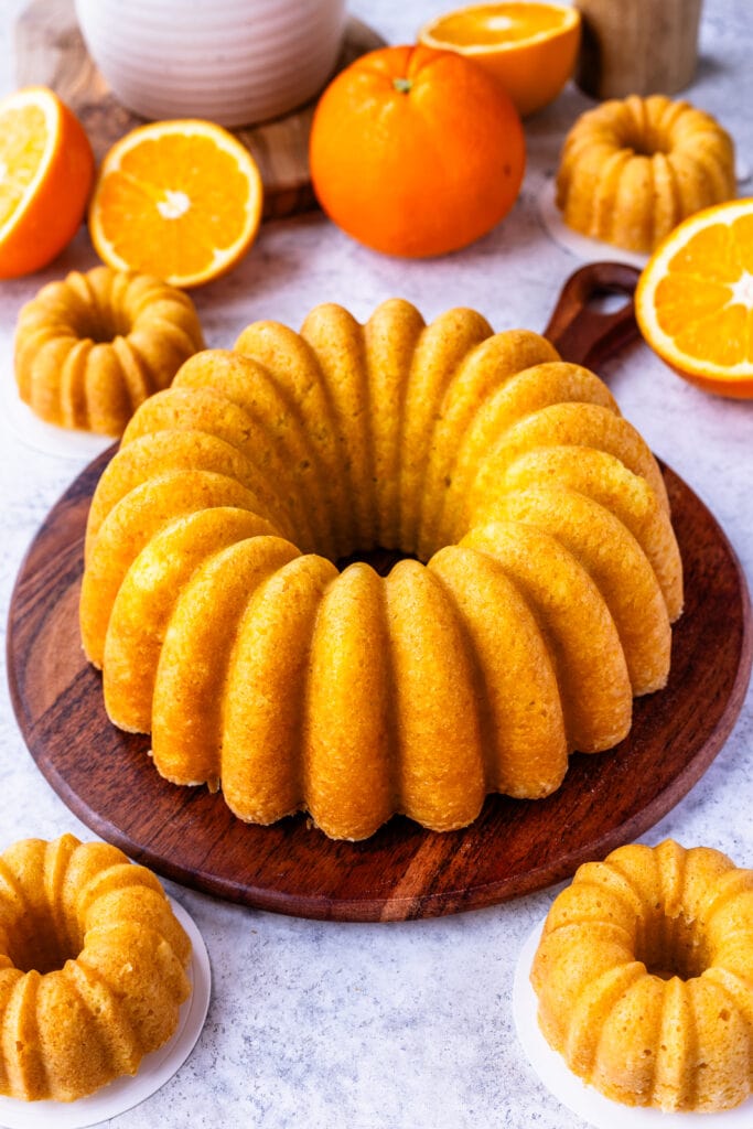 orange cake on top of a wooden board, without glaze on top.