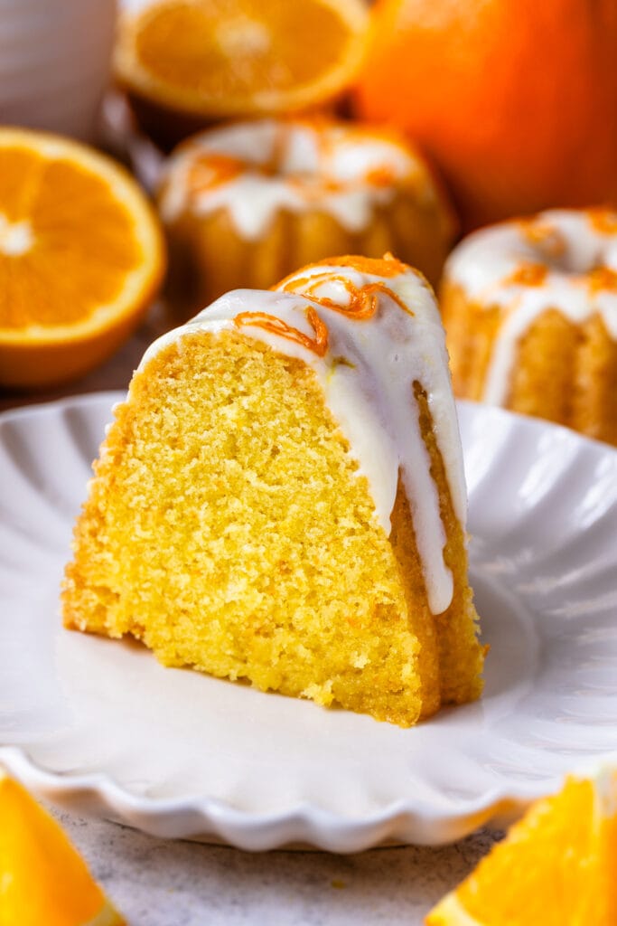 slice of orange cake with glaze on top and orange zest.