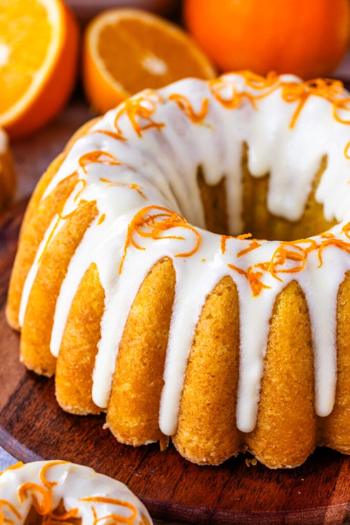 Orange cake with cream cheese glaze on top, and orange zest.