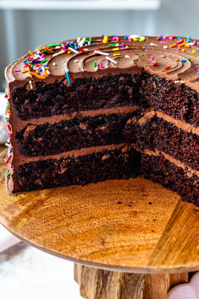 chocolate birthday cake on a cake stand, sliced.