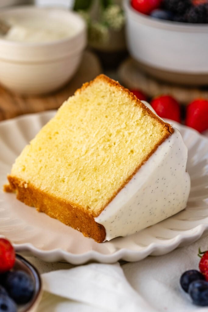 slice of cream cheese pound cake on a plate with glaze on top.