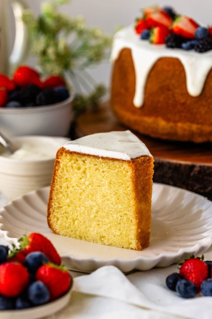 slice of cream cheese pound cake on a plate with glaze on top.