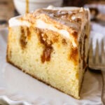 slice of caramel cake, with caramel filling, topped with cream cheese and caramel swirls.