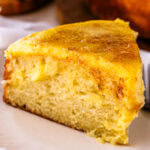 Crème Brûlée Cake slice on a plate, with custard on top of the cake and in the filling.