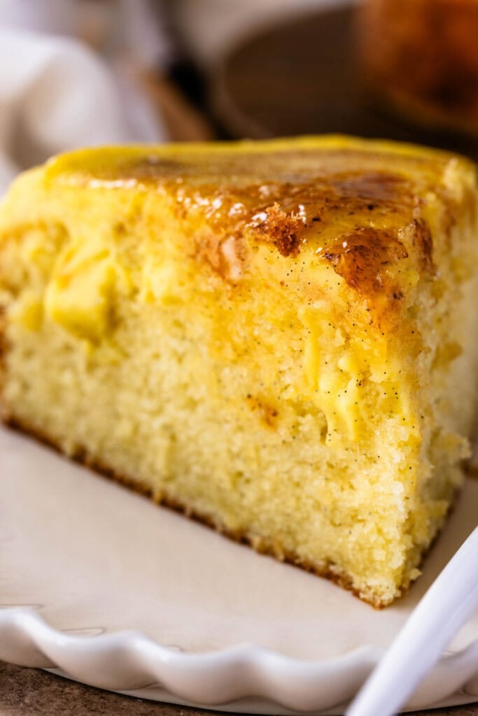 Crème Brûlée Cake slice on a plate, with custard on top of the cake and in the filling.