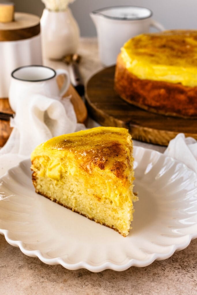 Crème Brûlée Cake slice on a plate, with custard on top of the cake and in the filling.