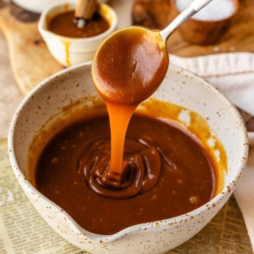 caramel sauce in a bowl with a spoon pouring caramel into the bowl.