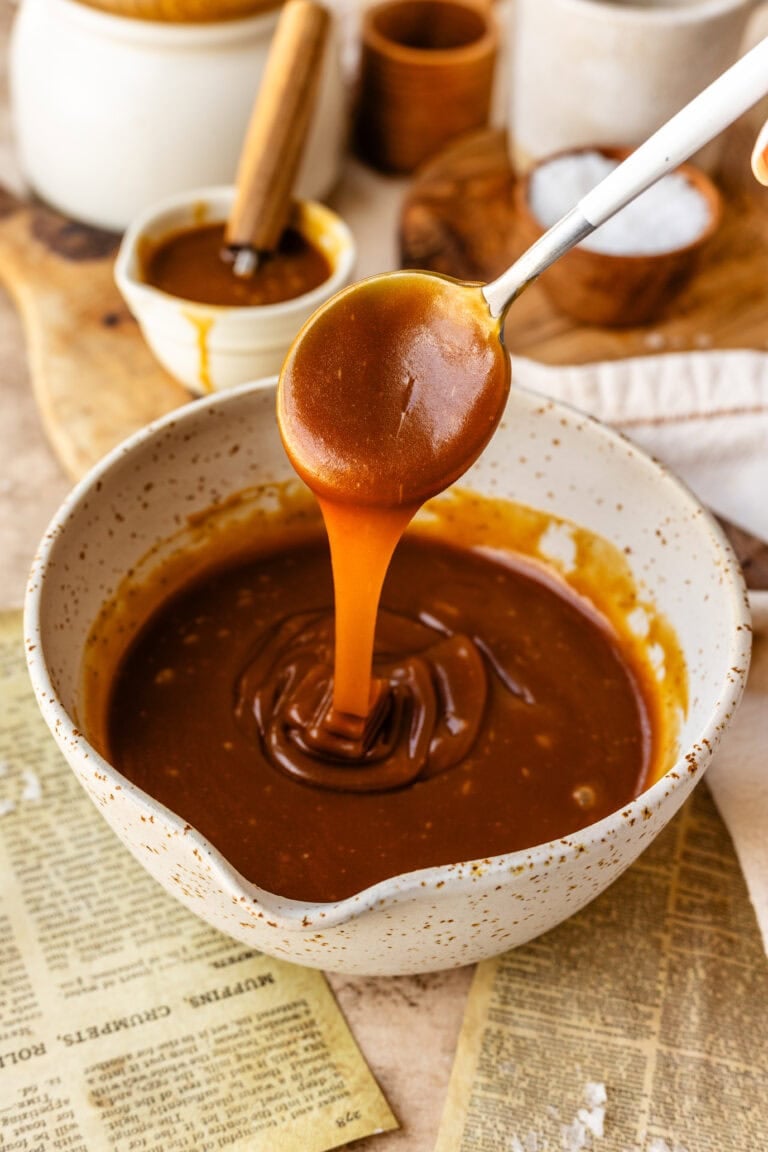 caramel sauce in a bowl with a spoon pouring caramel into the bowl.