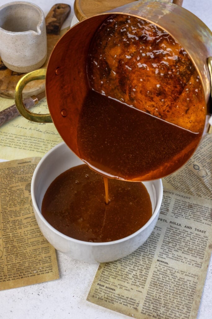 pouring caramel sauce into a bowl.