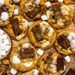S'mores cookies with pieces of chocolate, toasted marshmallows, and graham crackers.