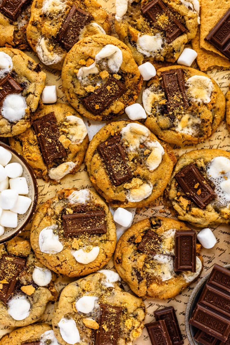 S'mores cookies with pieces of chocolate, toasted marshmallows, and graham crackers.