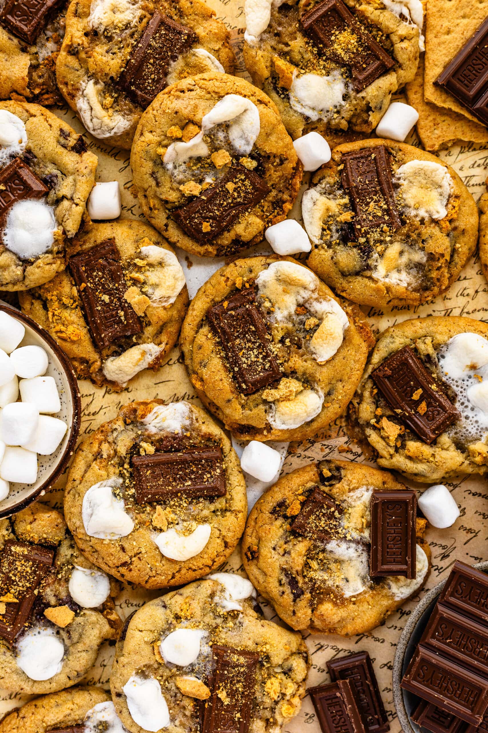 S'mores cookies with pieces of chocolate, toasted marshmallows, and graham crackers.