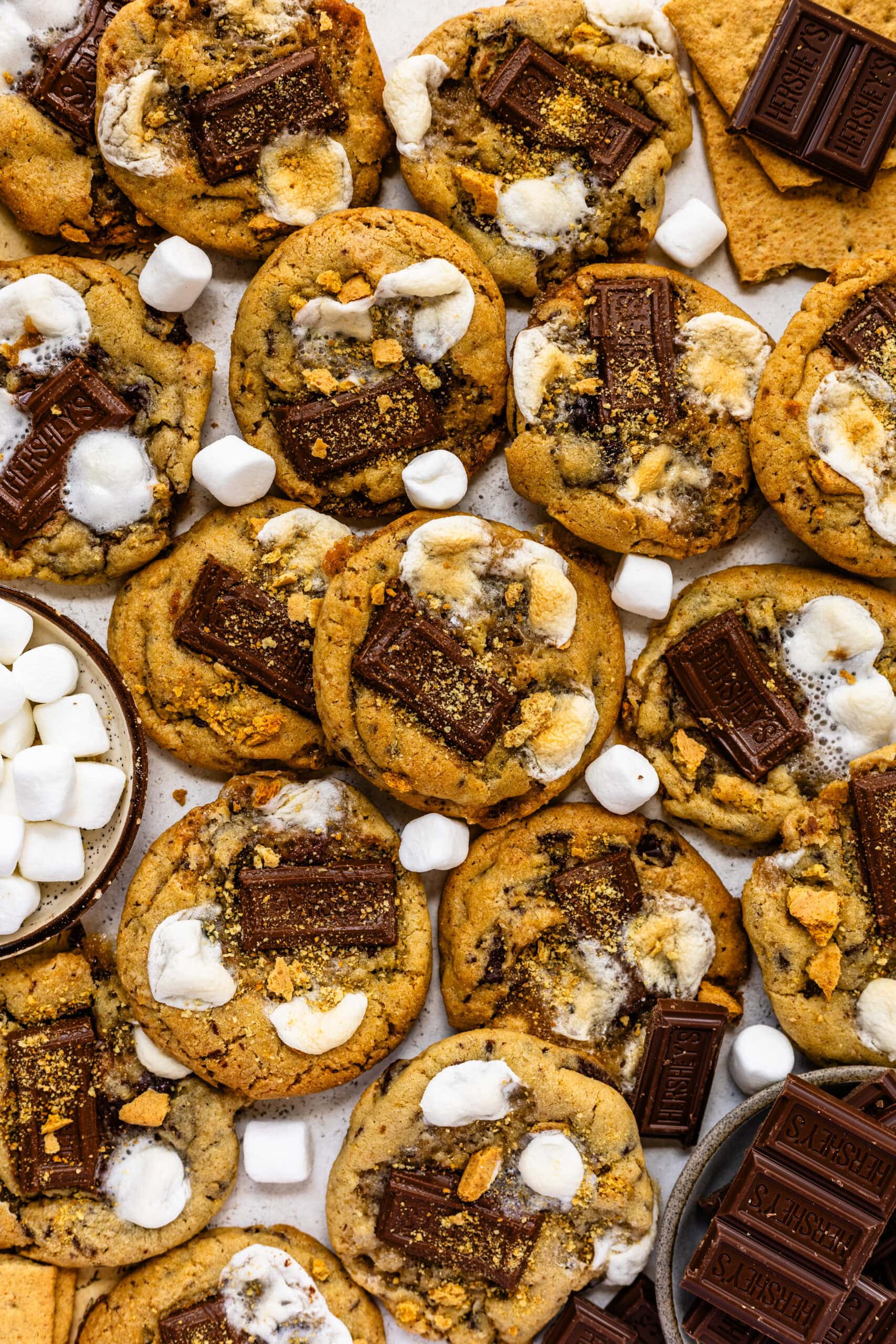 S'mores cookies with pieces of chocolate, toasted marshmallows, and graham crackers.