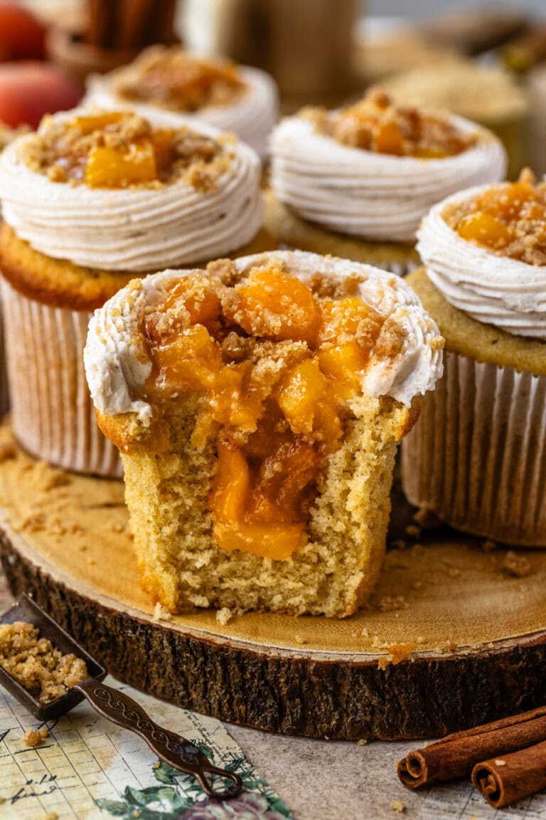 peach cupcakes filled with peaches, sliced in half showing the peach filling inside.