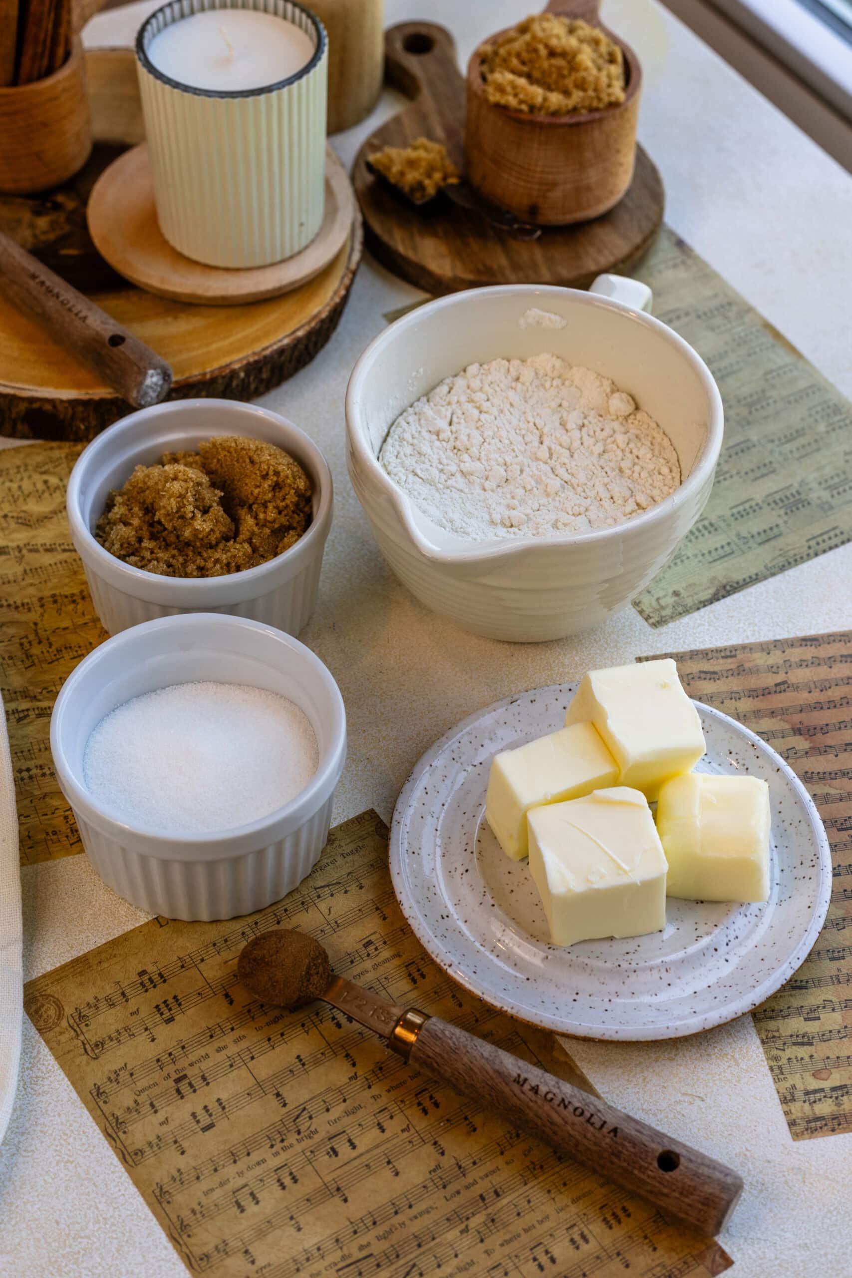 containers with the following ingredients: brown sugar, granulated sugar, all-purpose flour, butter, and a spoon with cinnamon.
