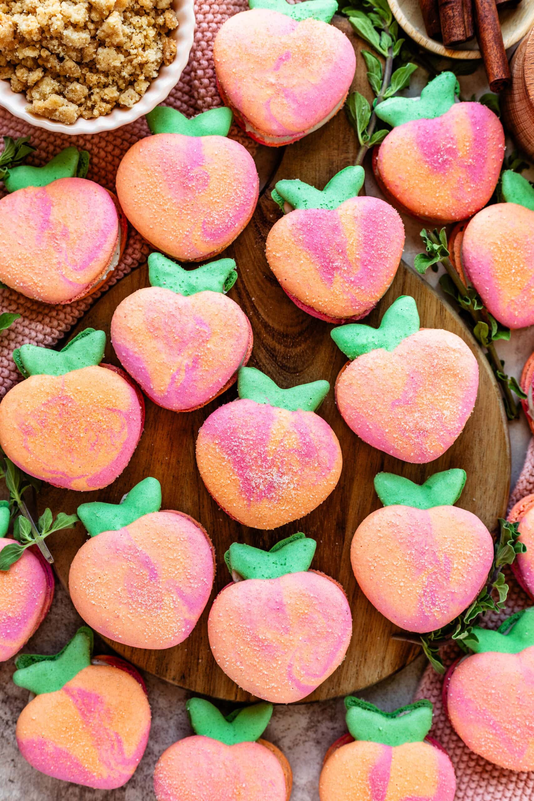 peach macarons on top of a wooden board.