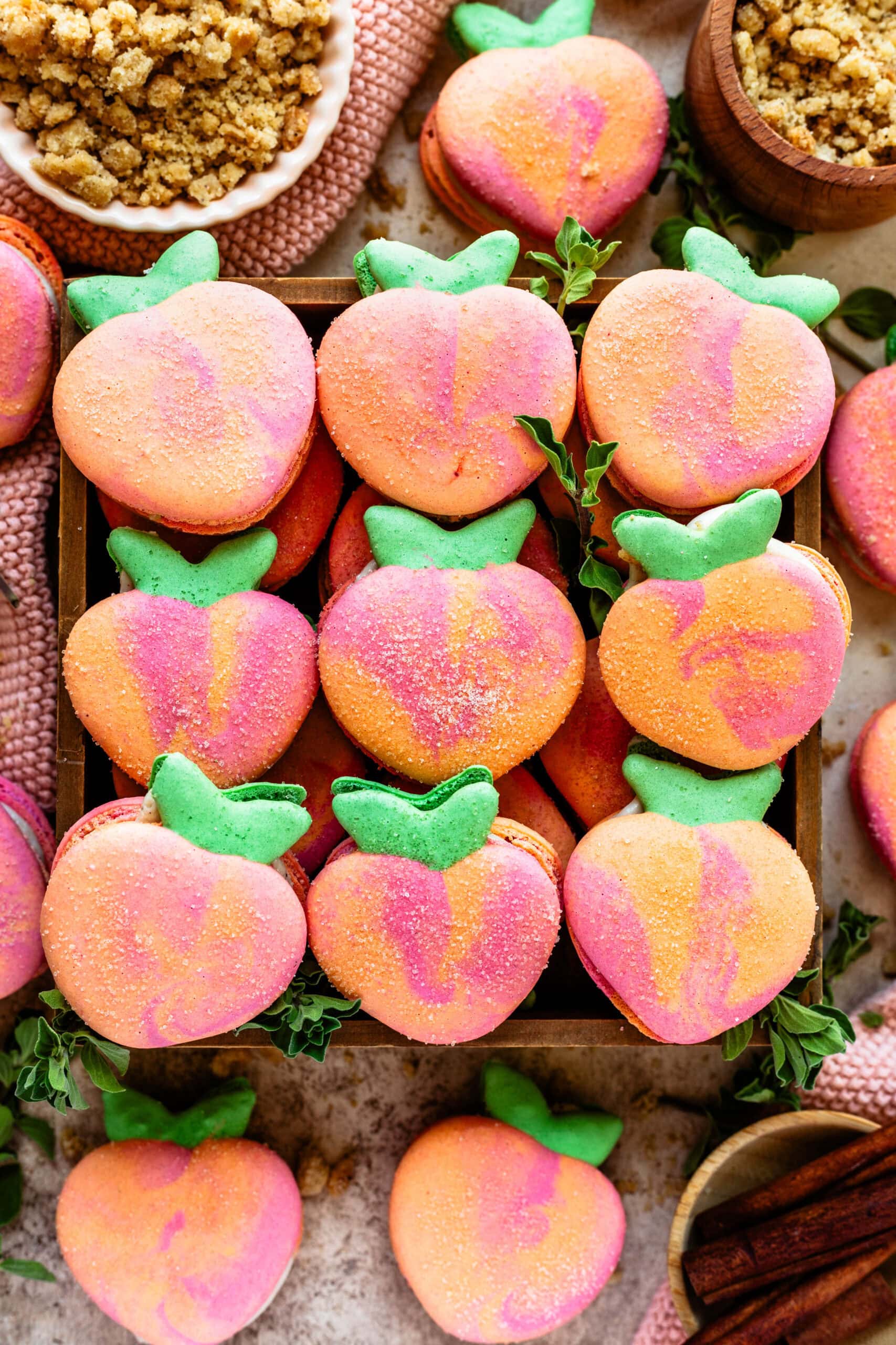 peach shaped macarons in a box.