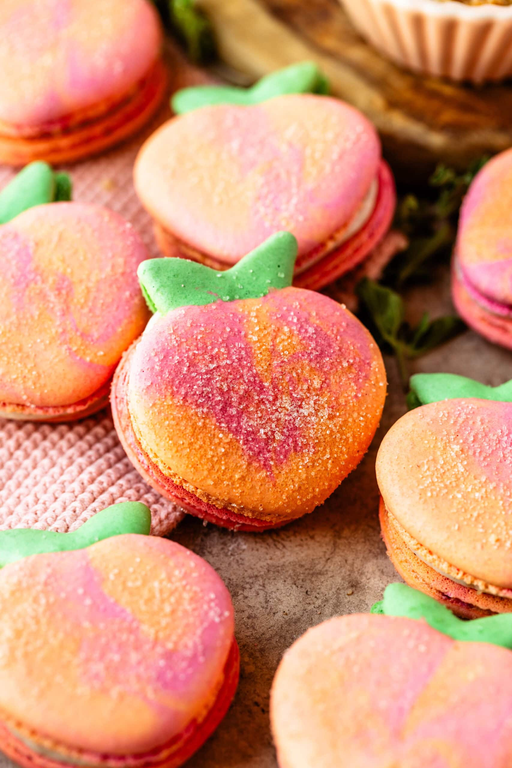 peach macarons with sugar sprinkled on top.