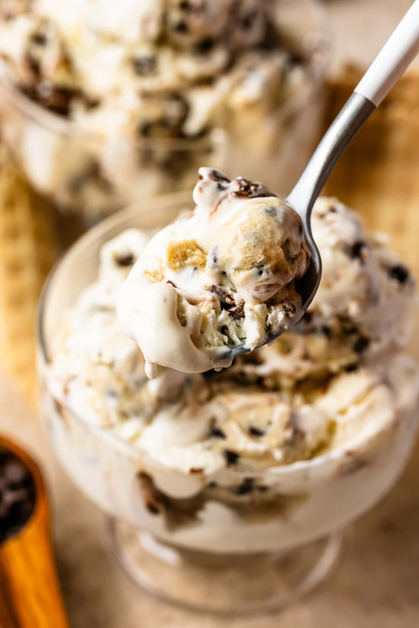 Close-up of a spoonful of cookie dough ice cream with chunks of cookie dough and chocolate chips.