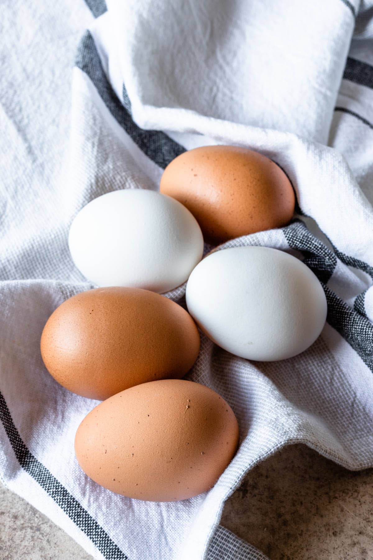 brown and white eggs on a towel.