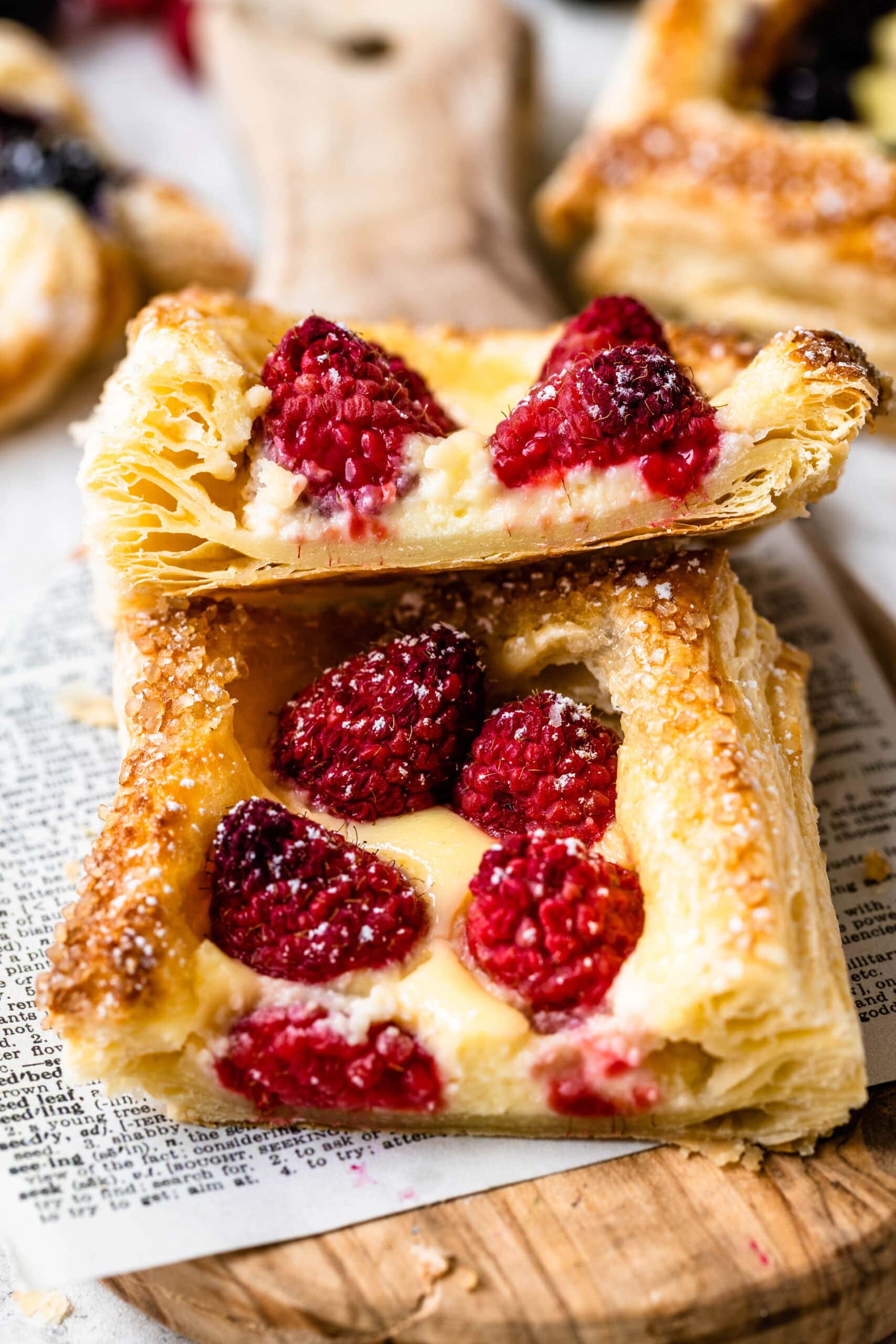 puff pastry baked to golden perfection with a cheese and raspberry filling, sliced in half.