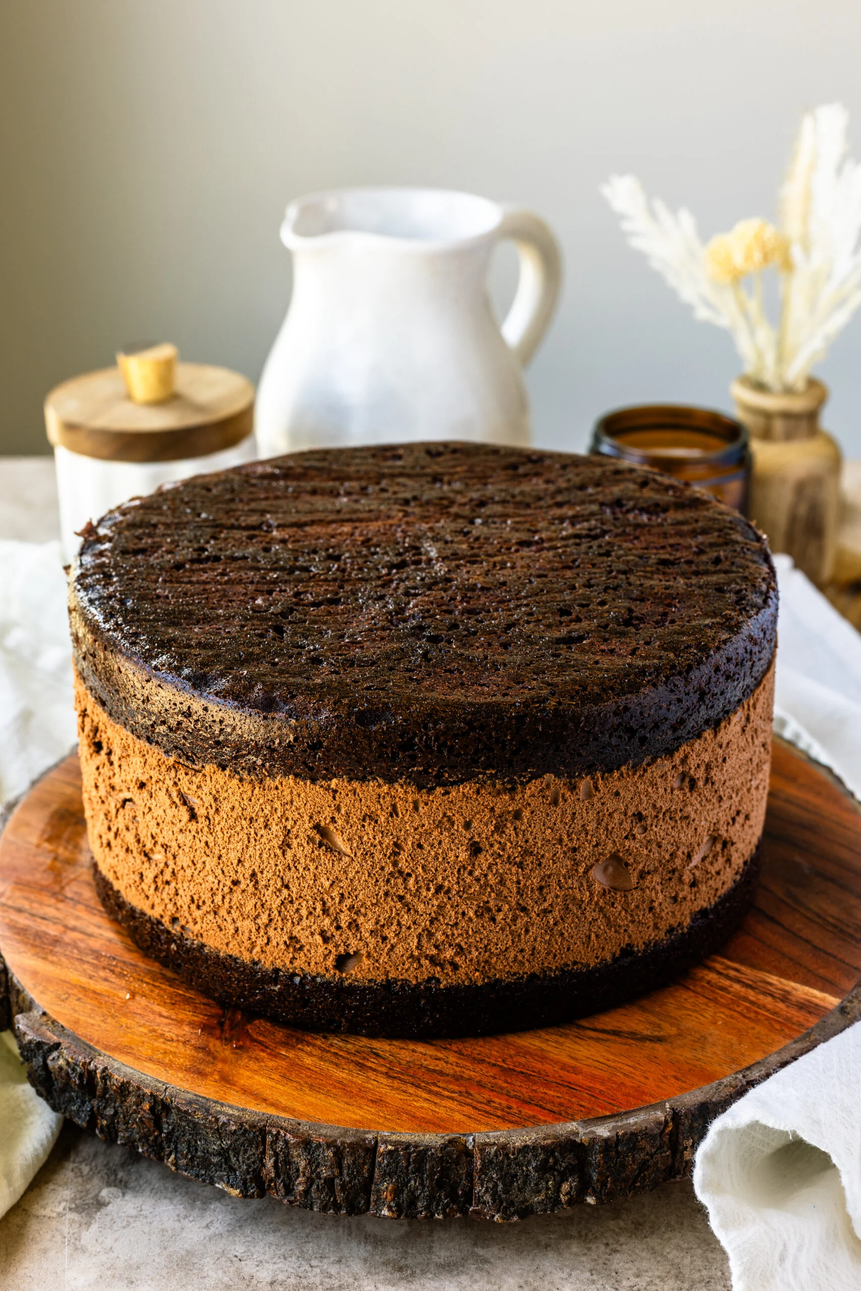 Chocolate mousse cake with its smooth layers and a rustic wooden base, ready for decorating or serving.