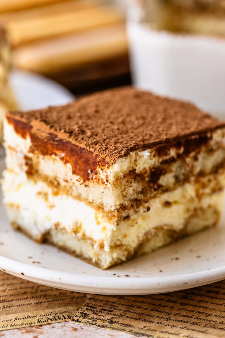 A slice of classic tiramisu with layers of espresso-soaked ladyfingers, mascarpone cream, and a cocoa-dusted top.