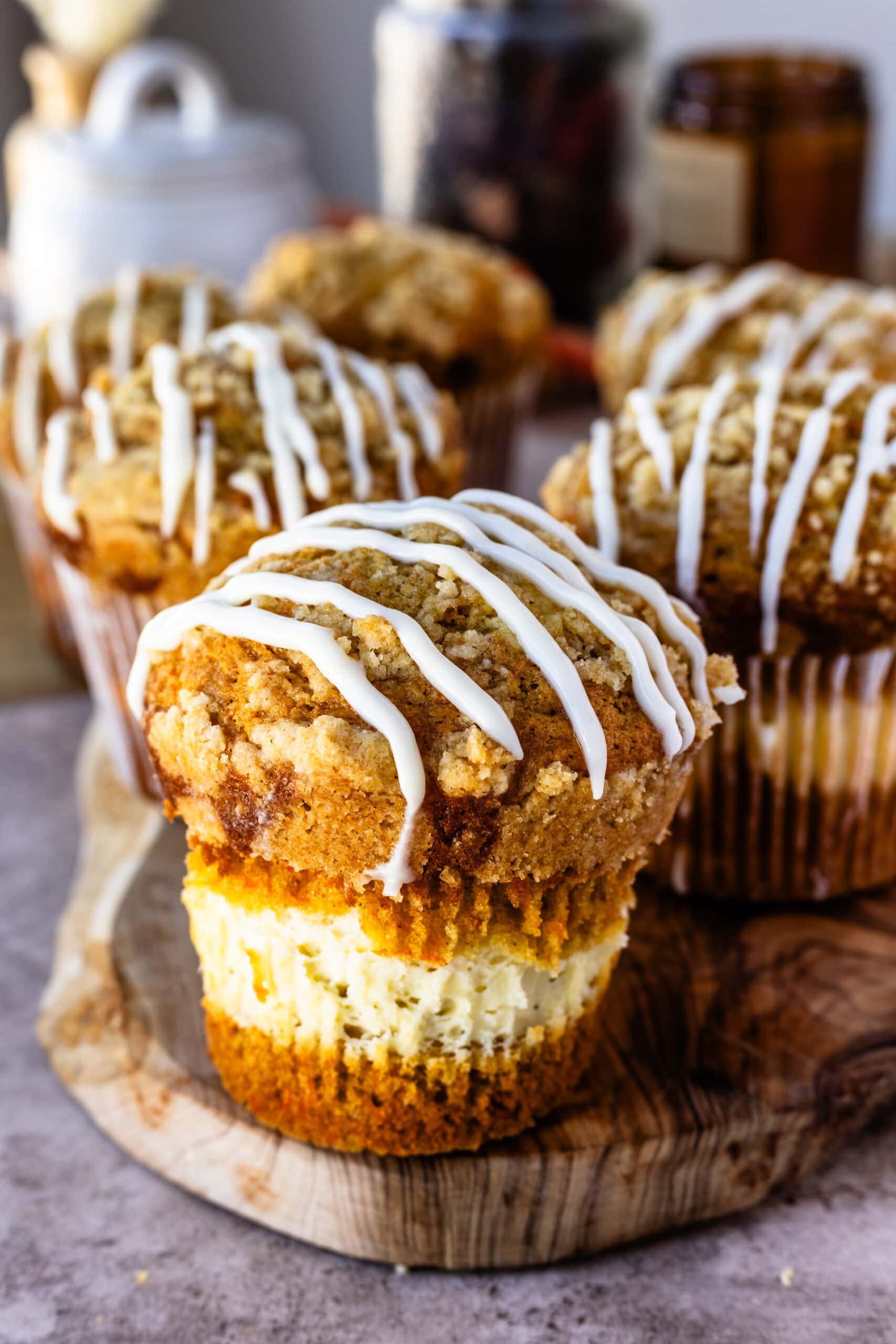 Fully finished and baked carrot cake muffins atop a wooden serving board ready to be eaten!