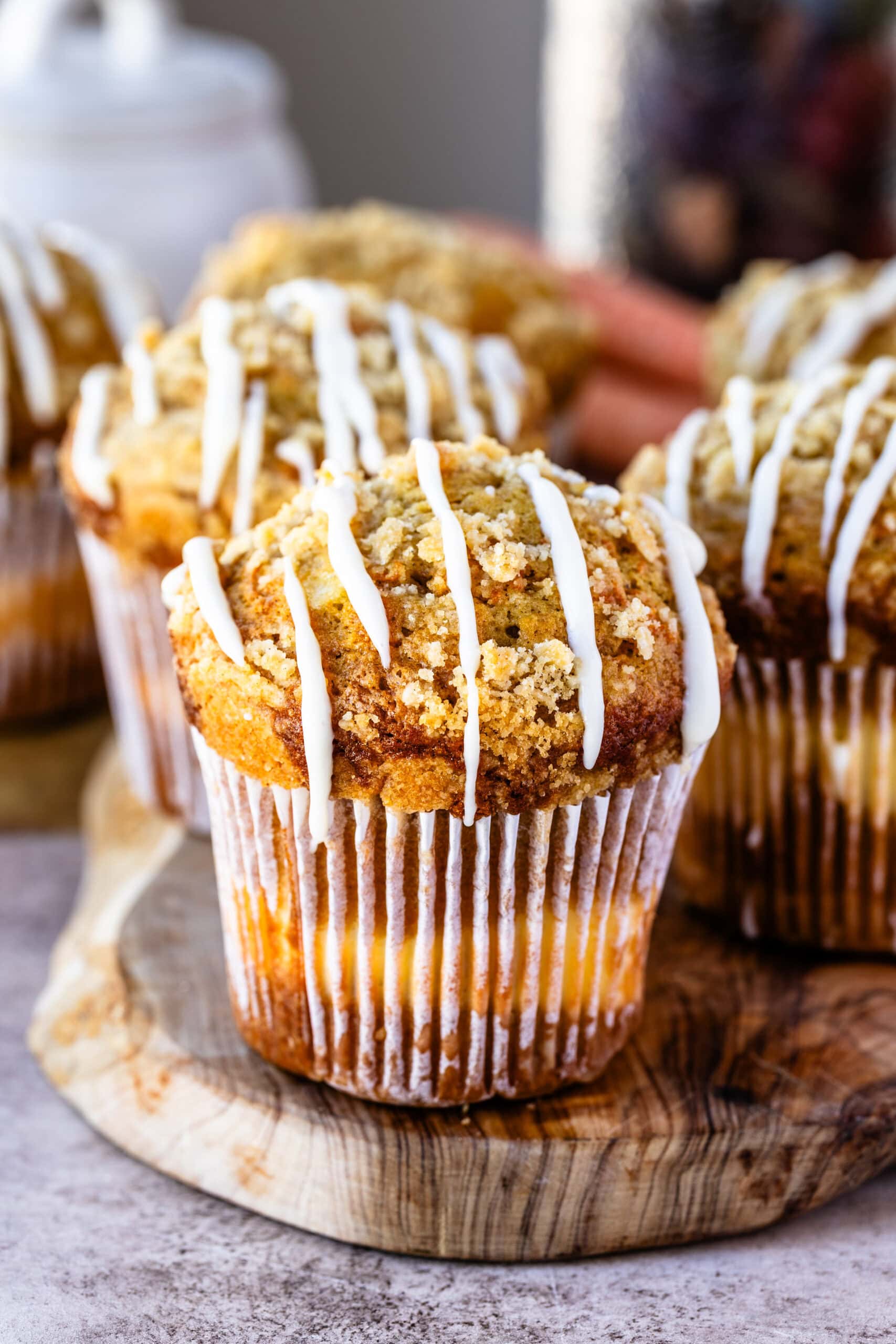 Fully finished and baked carrot cake muffins atop a wooden serving board ready to be eaten!