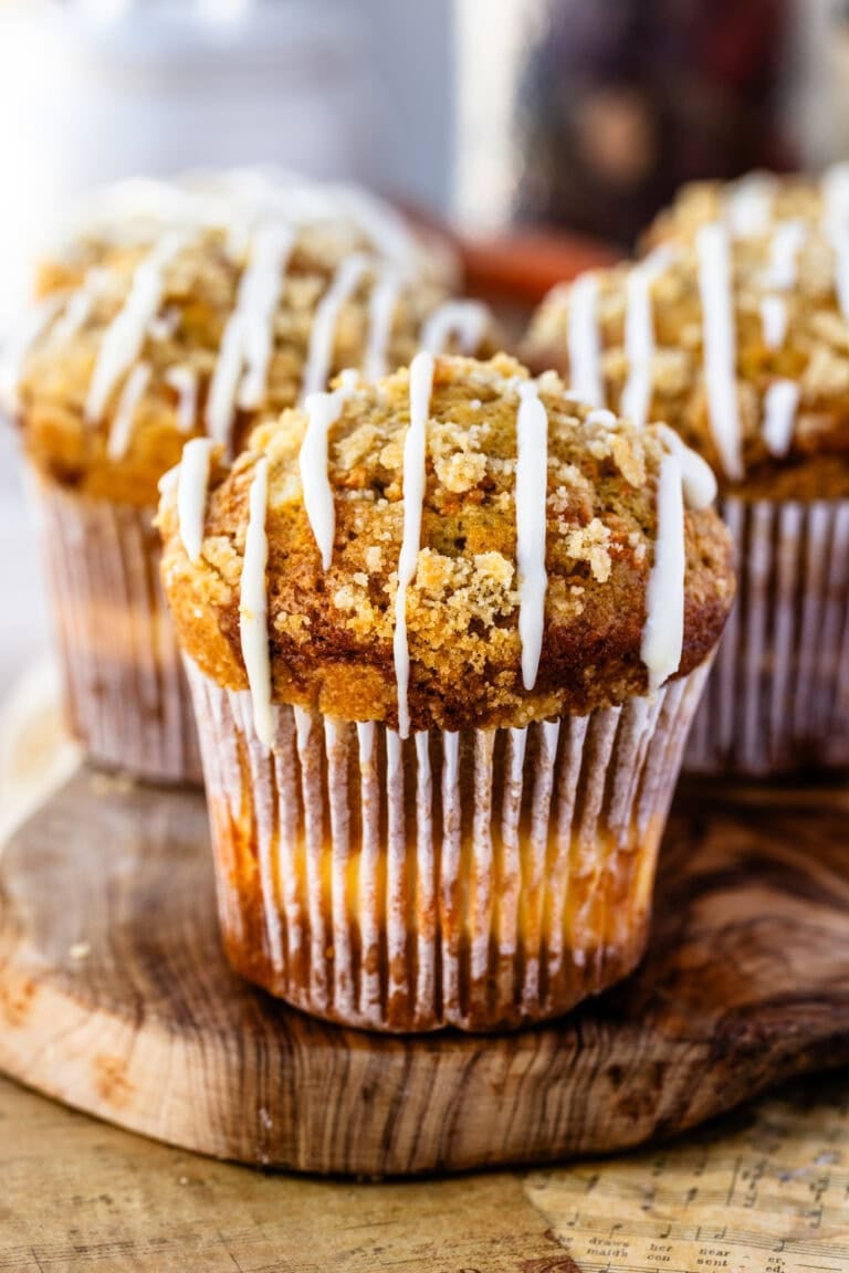 Fully finished and baked carrot cake muffins atop a wooden serving board ready to be eaten!