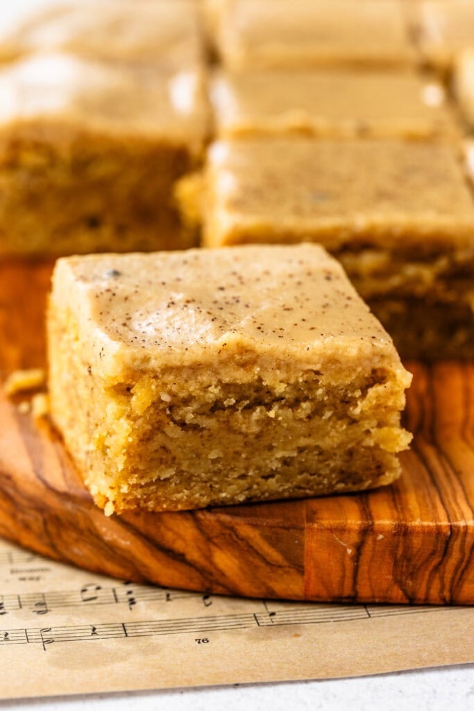 A single, beautiful slice of coffee blondie on top of a wooden serving board.