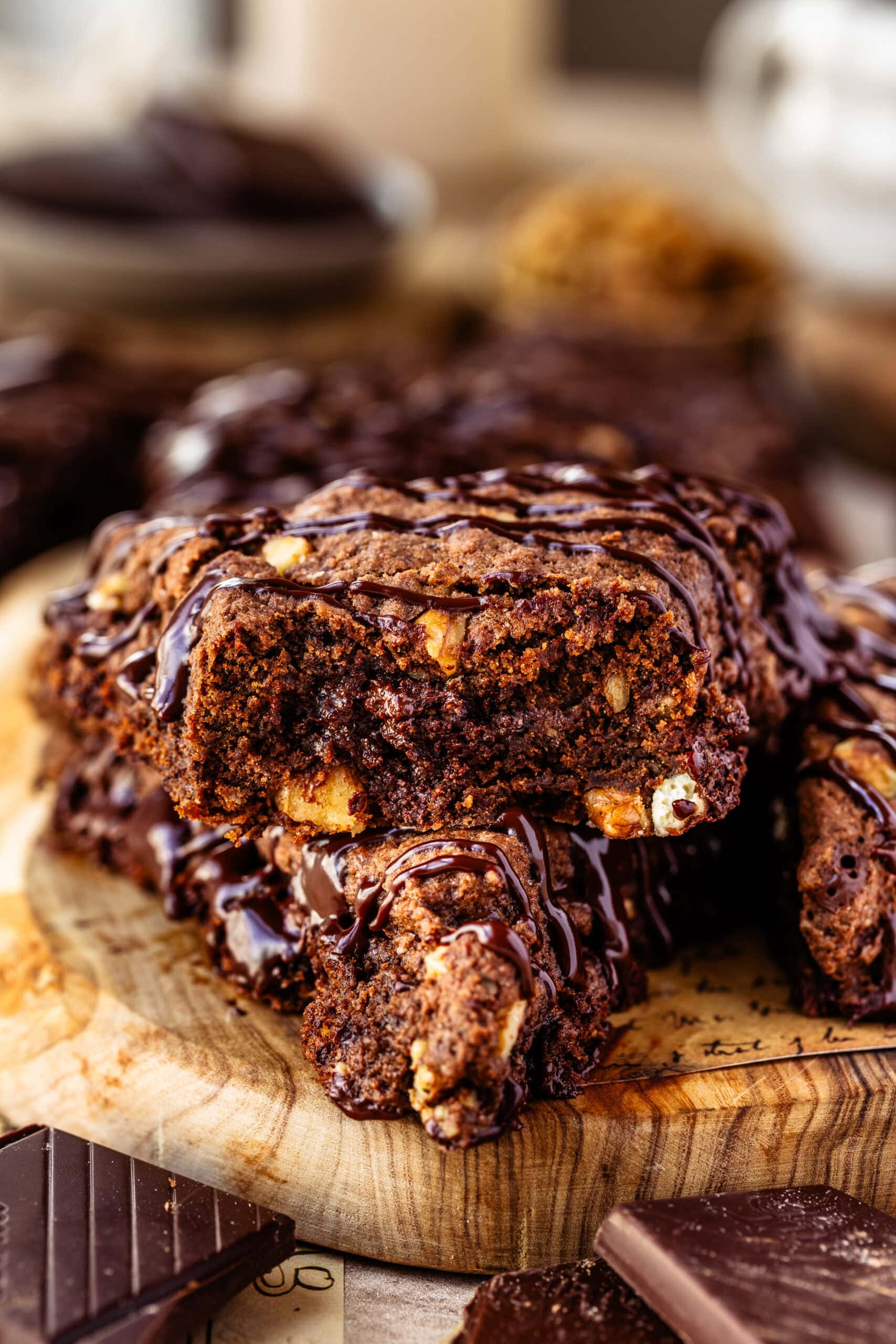 Two espresso chocolate scones stacked on top of each other. One of which has a bite taken out of it to show it's fudgy interior.