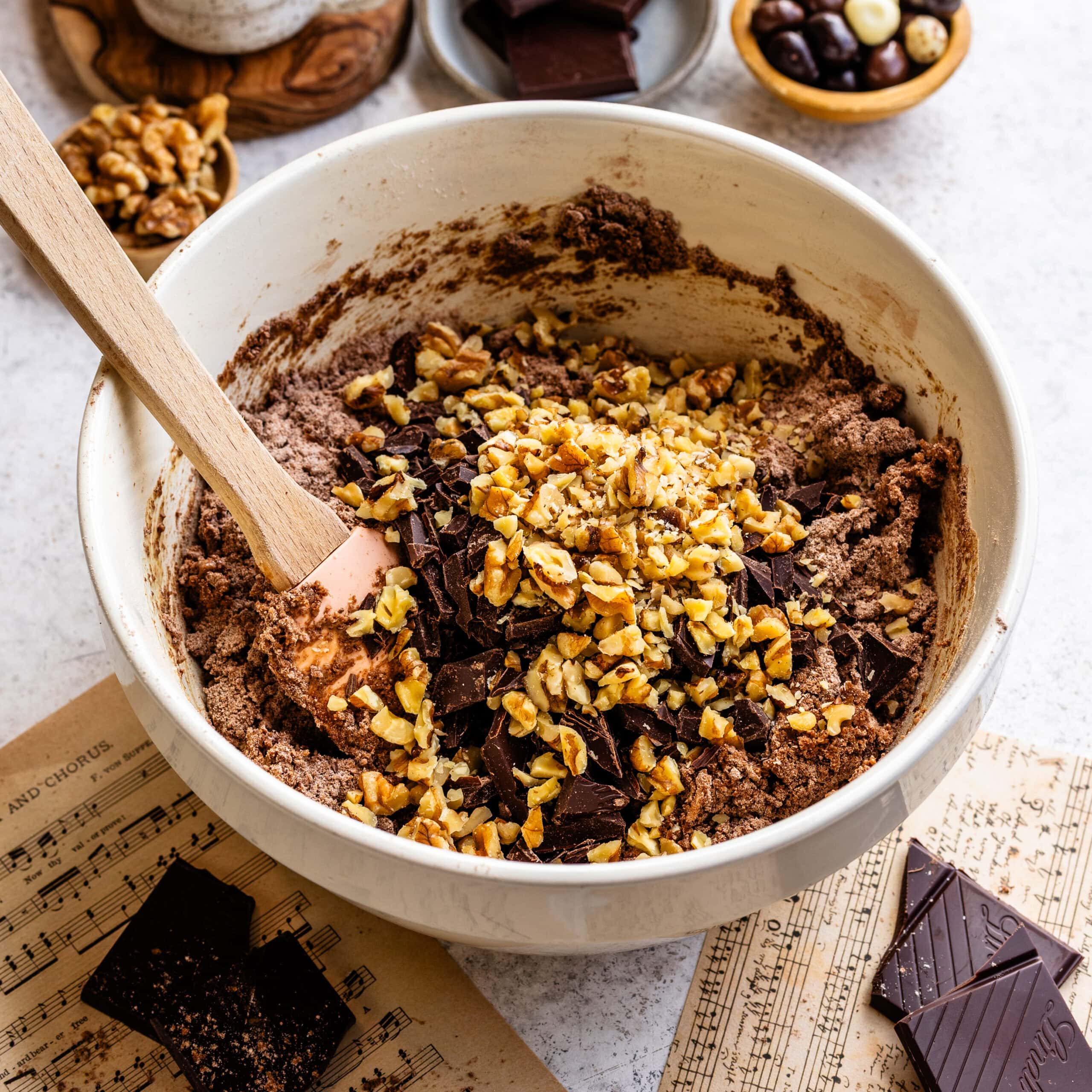 Walnuts and chopped chocolate being added to a crumbly espresso chocolate scone dough.