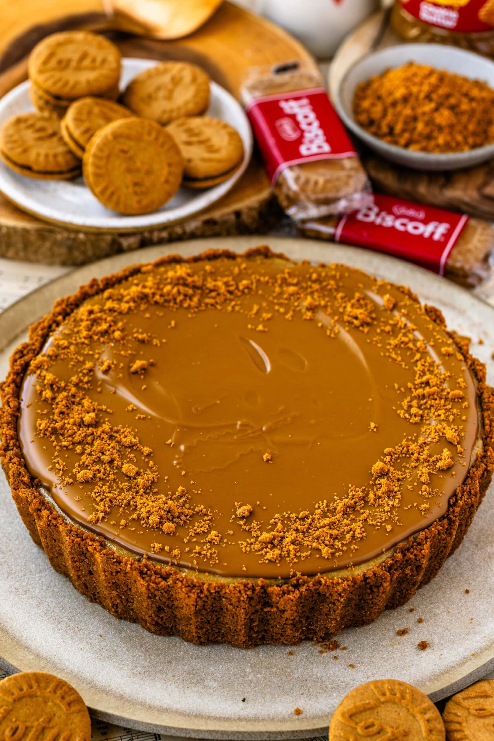 A Biscoff pie with a creamy cheesecake filling, Biscoff cookie crust, and smooth cookie butter topping sprinkled with crumbs.