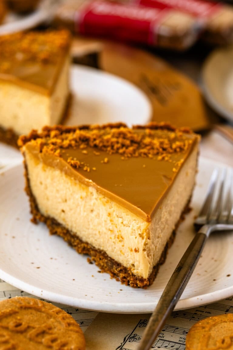 A slice of Biscoff pie with a creamy cheesecake filling, Biscoff cookie crust, and smooth cookie butter topping sprinkled with crumbs.